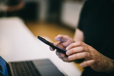 Midsection of man using mobile phone