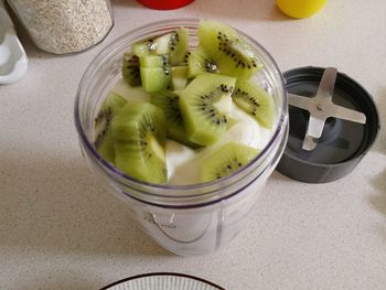 High angle view of kiwi and fruits in container on table