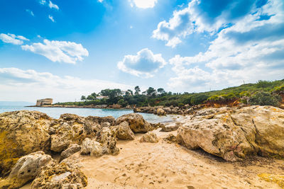 Rocks on beach against sky