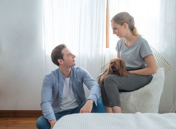 Woman with dog sitting at home