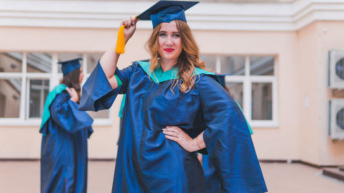 Portrait of woman standing against blue wall