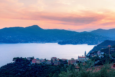 Panoramic view of buildings and mountains against sky during sunset