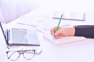 Close-up of man using laptop on table