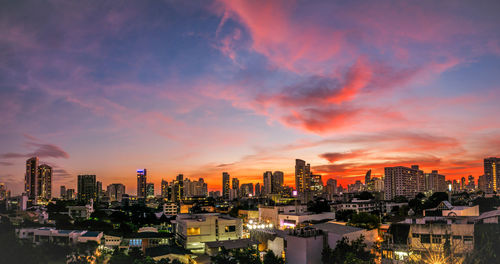 Illuminated buildings against sky during sunset