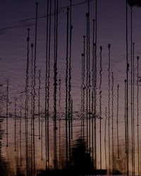 Silhouette electricity pylon against sky at sunset