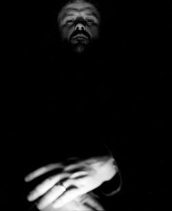 Close-up portrait of man against black background