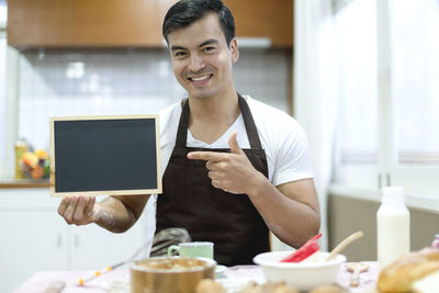 Portrait of man holding blank slate