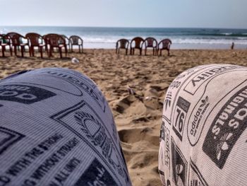 Close-up of lounge chairs on beach