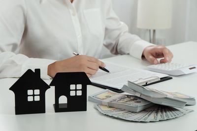 Midsection of a woman holding paper