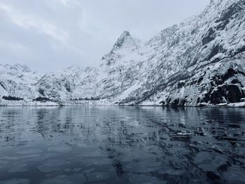 Scenic view of lake and snowcapped mountains against sky