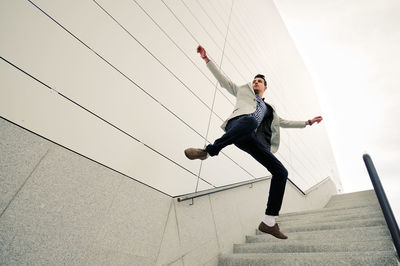 Full length of businessman levitating against building