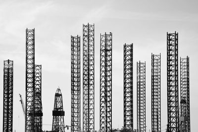 Low angle view of cranes against sky