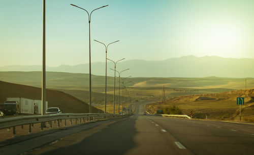 Empty road against sky during sunset