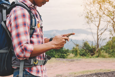 Midsection of man using mobile phone