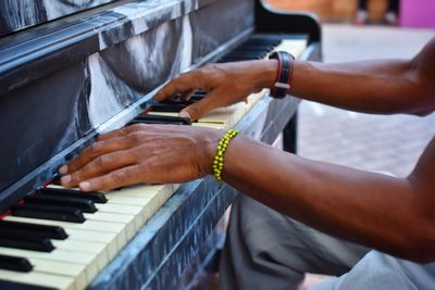 Midsection of man playing piano