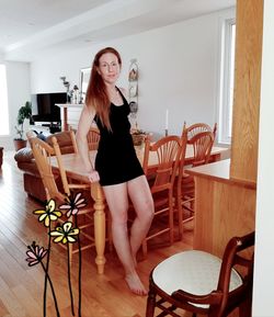 Portrait of young woman sitting on chair at home