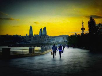 People walking in city during sunset