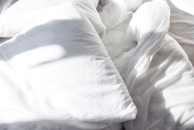 Full frame shot of white sheets on bed