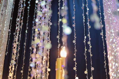 Close-up of illuminated lights hanging on window