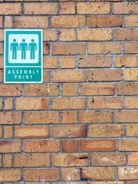 Close-up of arrow sign on brick wall