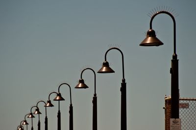 Illuminated street light against sky