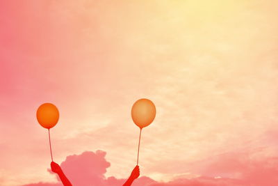 Balloons against orange sky