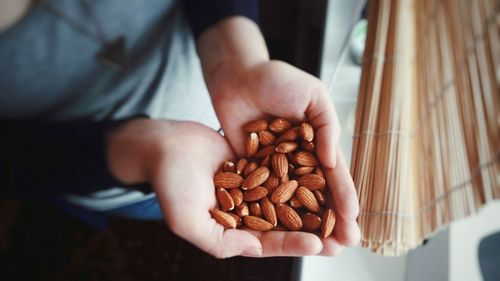 Midsection of woman holding almonds