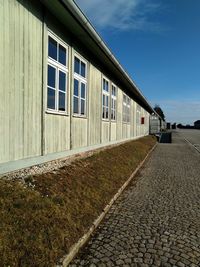 Surface level of footpath by building against sky