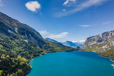 Scenic view of lake and mountains against blue sky