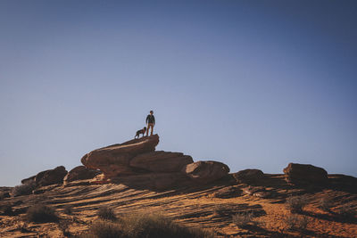 A man with a dog is standing near horseshoe bend, arizona