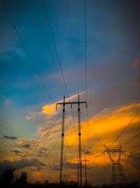 Low angle view of electricity pylon against sky during sunset