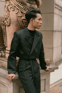 Young man standing against wall