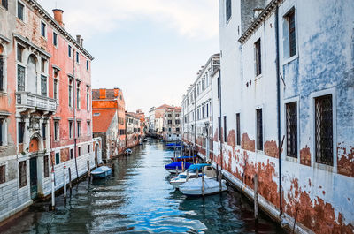 Boats moored in canal along built structures