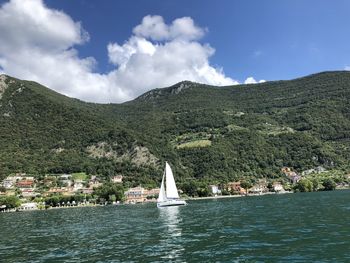 Scenic view of sea by mountains against sky