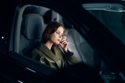 Young woman sitting in car