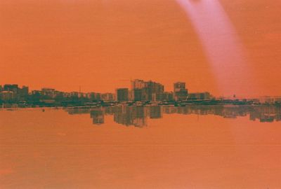 Reflection of buildings in water at sunset