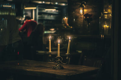 Close-up of burning candles on table at restaurant