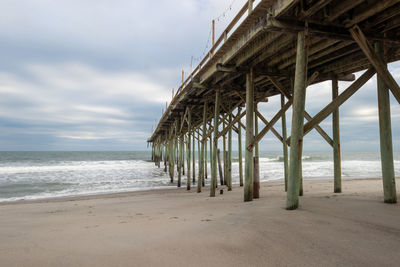 Wooden fishing pier on a beach by the ocean