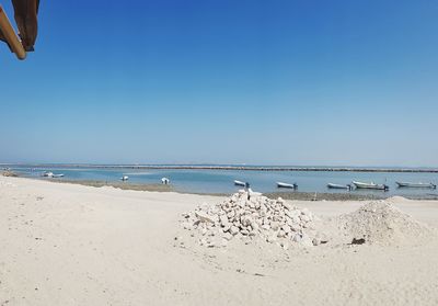 Scenic view of beach against clear blue sky