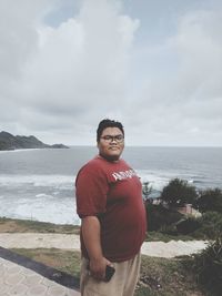 Man standing at beach against sky