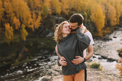 Happy people in love are travel hike in nature in the autumn forest. romantic trip to countryside