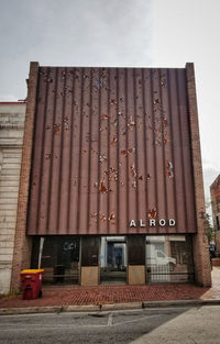 Low angle view of text on building against sky