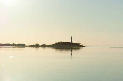 Scenic view of lake against clear sky during sunset