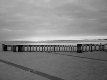 Pier on sea against cloudy sky