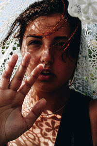 Close-up portrait of young woman gesturing while wearing scarf