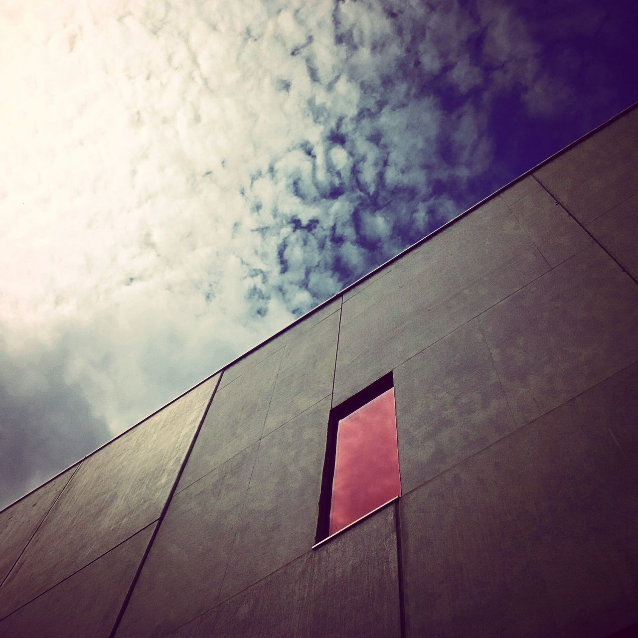 architecture, built structure, building exterior, low angle view, sky, cloud - sky, building, window, cloudy, wall - building feature, cloud, no people, day, outdoors, high section, wall, residential structure, city, residential building, brick wall