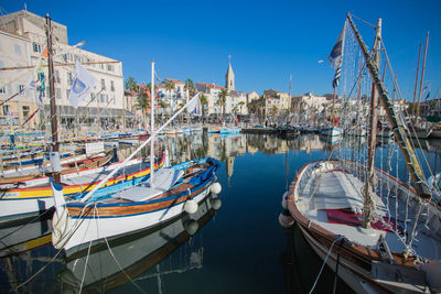 Sailboats moored in harbor