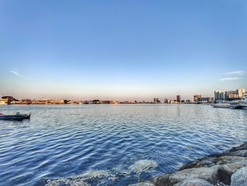 Scenic view of sea and buildings against blue sky