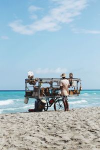 Rear view of male vendor with food stall at beach