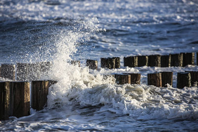 Close-up of water splashing on wooden post in sea